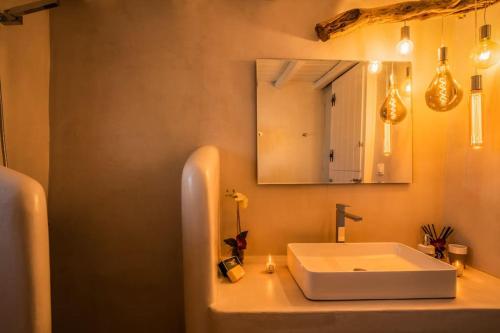 a bathroom with a white sink and a mirror at Armonia Guesthouse close to Mykonos town in Dexamenes
