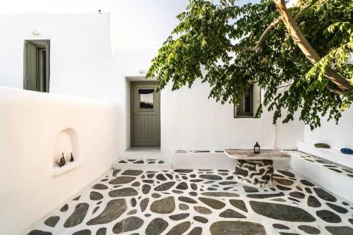 um quarto com piso de pedra e uma árvore em Armonia Guesthouse close to Mykonos town em Dexamenes
