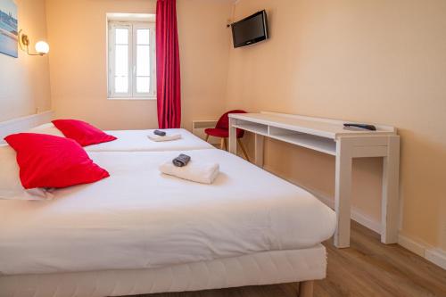two beds in a room with a desk and a computer at Hôtel de la Mairie in Saint-Pol-de-Léon