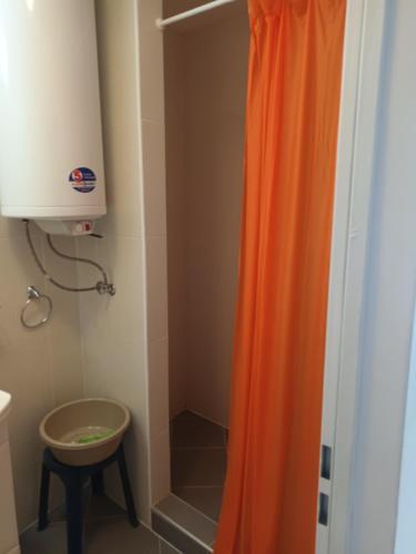 uma cortina de chuveiro laranja na casa de banho com um banco em Relaks w Marina Cape 88 em Aheloy