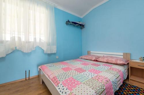 Schlafzimmer mit einem Bett mit blauer Wand in der Unterkunft Apartment Denis in Marina