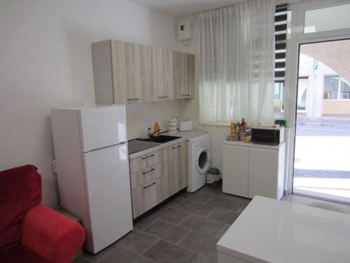 una cucina con frigorifero bianco e lavatrice di da Paola monolocale a Osoppo