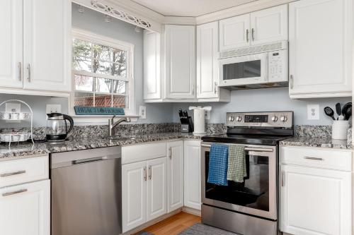 a kitchen with white cabinets and stainless steel appliances at Neptune By The Water in Annapolis