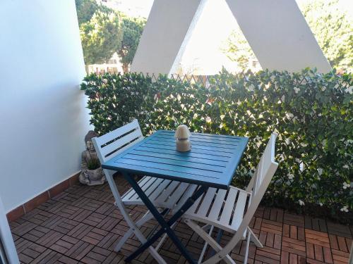 una mesa azul y 2 sillas en el patio en Joli studio point zéro, en La Grande-Motte