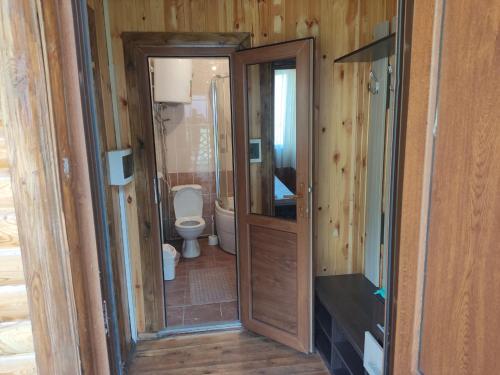 baño con aseo y puerta de madera en Shaa-boto, en Alamedin