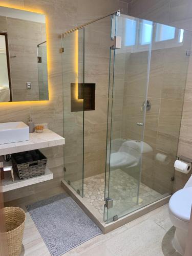 a glass shower stall in a bathroom with a toilet at Departamento de Lujo & Club de Playa in Acapulco
