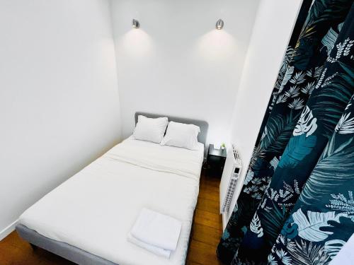 Cette petite chambre comprend un lit et un rideau. dans l'établissement Montpellier Cœur Lumière, à Montpellier