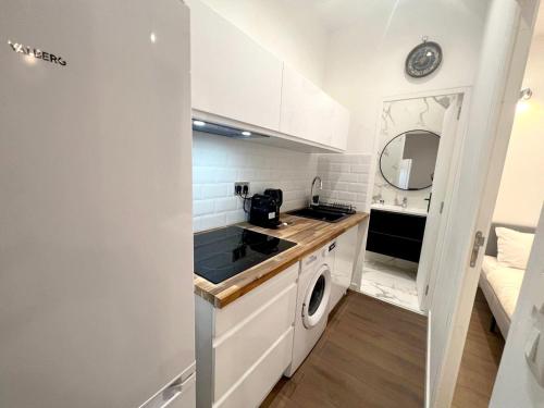 une petite cuisine blanche avec lave-linge et sèche-linge dans l'établissement Montpellier Cœur Lumière, à Montpellier