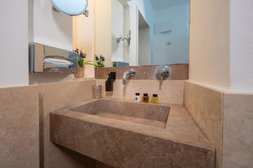 La salle de bains est pourvue d'un grand lavabo et d'un miroir. dans l'établissement Palazzo Personè Dimora Storica, à Lecce