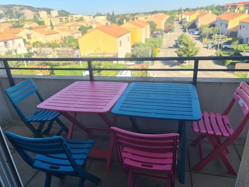 d'une table et de chaises sur un balcon avec vue sur la rue. dans l'établissement Joli studio calme et balcon au cœur du Lubéron proche du centre et gare, à Cavaillon