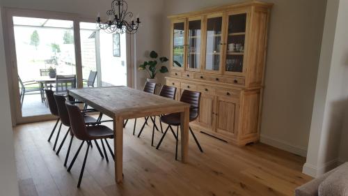 a dining room with a wooden table and chairs at B&B Krieken de Jour in Ninove