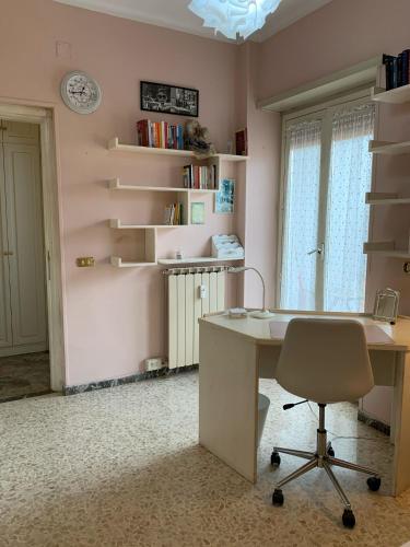 Una oficina con un escritorio, una silla y estantes. en GRAZIOSO MONOLOCALE OSTIA ROMA, en Lido di Ostia