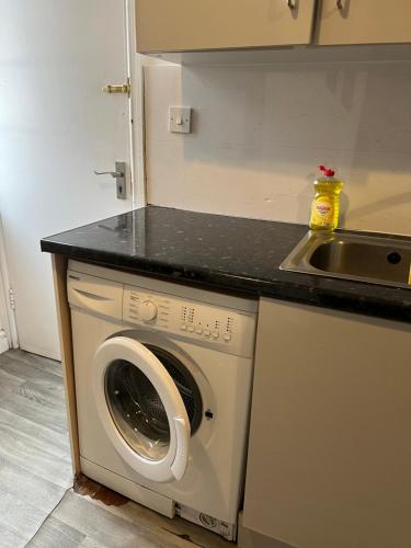 een keuken met een wasmachine en een wastafel bij City Urban Apartments in Birmingham