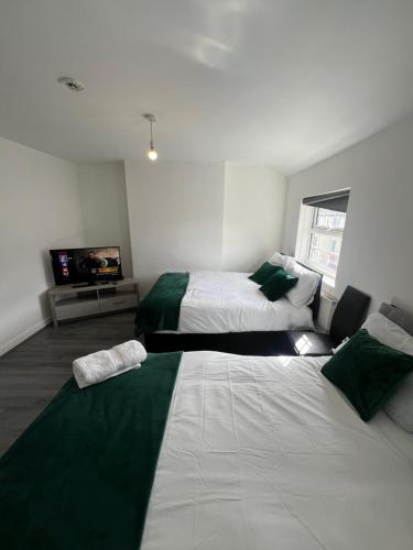 een slaapkamer met 2 bedden en een flatscreen-tv bij City Urban Apartments in Birmingham