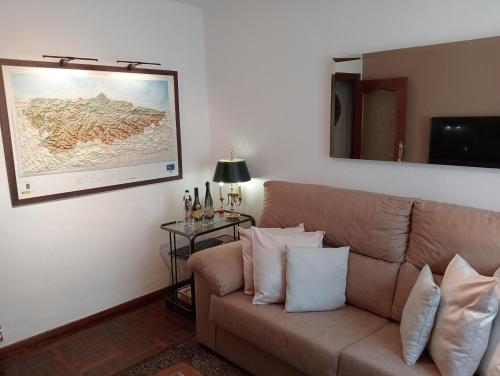 un soggiorno con divano e una foto appesa al muro di Habitacion matrimonial centro ciudad a Oviedo