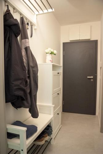 a walk in closet with a white cabinet and a black door at Apartmán víla Amálka in Janov nad Nisou