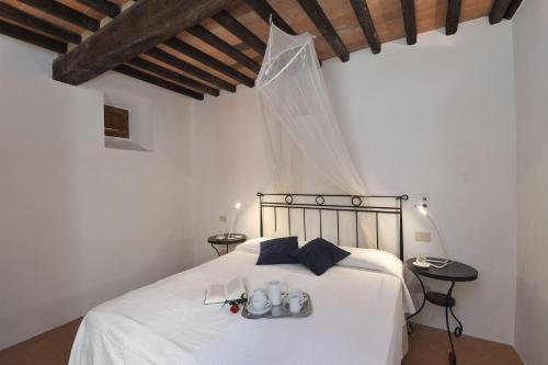 a bedroom with a white bed with shoes on it at Mantegna in Gaiole in Chianti