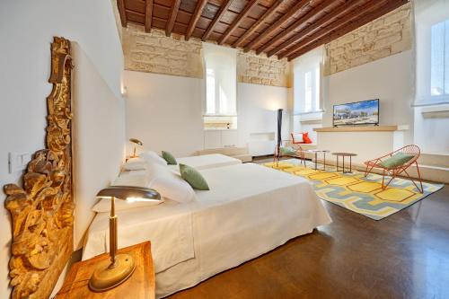 a bedroom with a large bed and a living room at Palazzo Personè Dimora Storica in Lecce