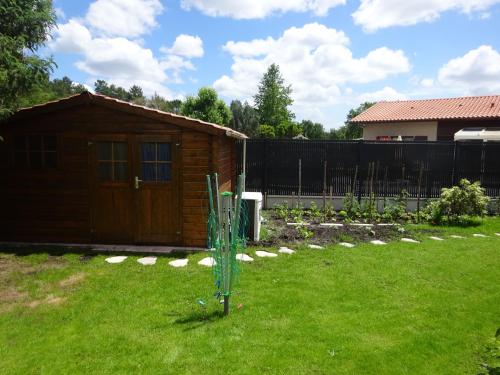un petit hangar en bois dans une cour avec une clôture dans l'établissement Landaise idéale pour 1 à 2 couples avec enfants, à Azur