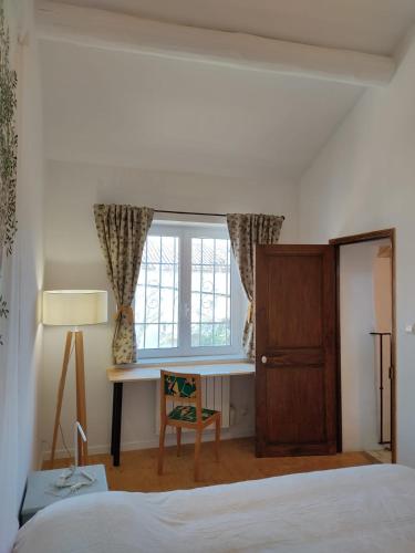 une chambre avec un lit, un bureau et une fenêtre dans l'établissement Pra Marri, à Malemort-du-Comtat