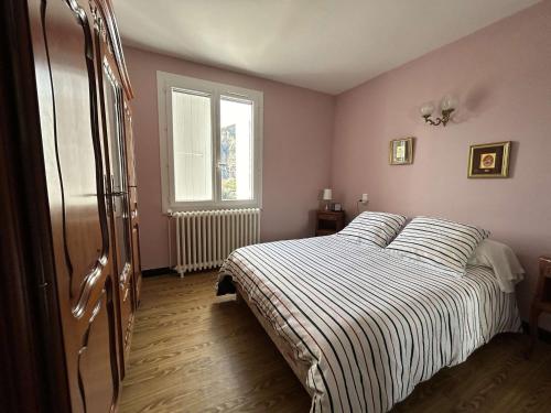 une chambre avec un lit avec une couverture rayée dans l'établissement Maison climatisée 3 chambres avec terrasse, grand terrain et accès rivière, proche Vallon Pont d'Arc - FR-1-382-118, à Vallon-Pont-dʼArc