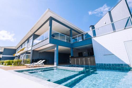 uma casa com piscina em frente a um edifício em VELINN Angra Sunset Hotel & Villas em Angra dos Reis
