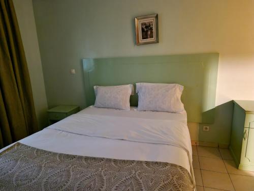 ein Bett mit zwei Kissen auf einem Zimmer in der Unterkunft Association LES PYRAMIDES GABON in Libreville