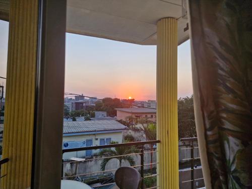 uma vista para o pôr-do-sol a partir de uma varanda em Association LES PYRAMIDES GABON em Libreville