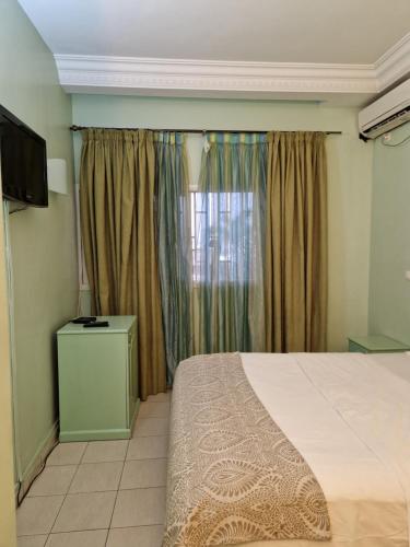 a bedroom with a large bed and a window at Association LES PYRAMIDES GABON in Libreville