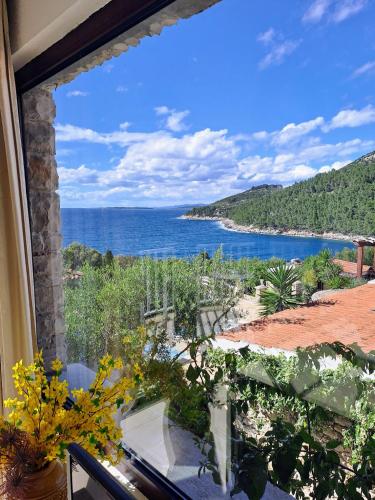 a view of the ocean from a house window at Villa Stone House Poplat in Vela Luka