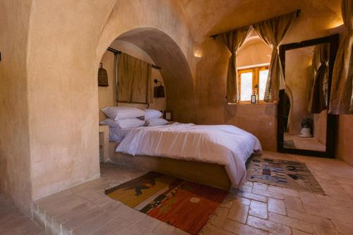 una camera con letto in una stanza con arco di Tzila Lodge a Fayoum