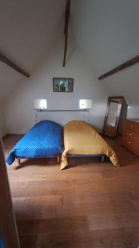 a bedroom with a bed with a blue blanket and two lights at gite de la Chevrie in La Baconnière