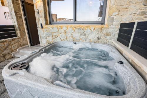 a jacuzzi tub with snow inside of it at Celeste Junior Suite on the Beach in Nea Kydonia