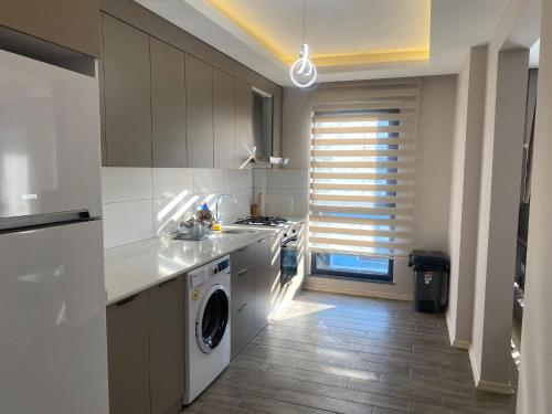a kitchen with a sink and a washing machine at Rosella Royal Suit - روزيلا رويال in Trabzon