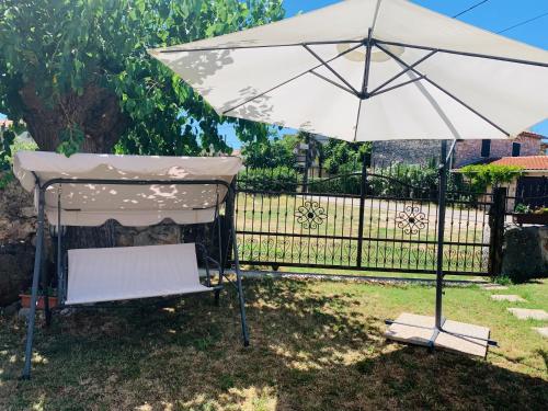 a white umbrella and a chair under a table at Apartment in Poreč, Croatia in Nova Vas