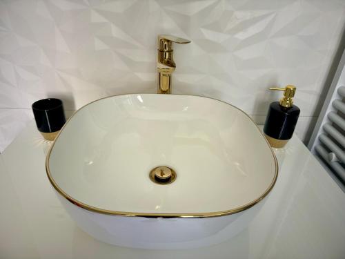 a white sink with two black cups on a counter at Sun Fun APT in Omiš