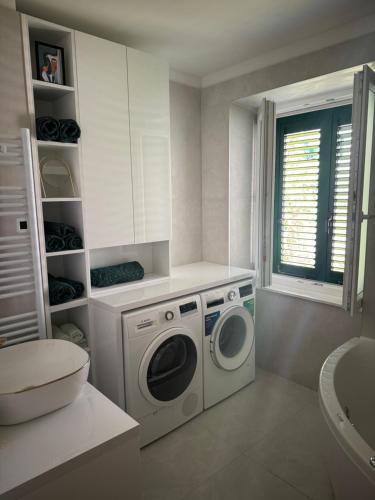a bathroom with a washing machine and a toilet at Sun Fun APT in Omiš