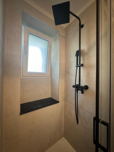 a shower with a window in a bathroom at Sun Fun APT in Omiš