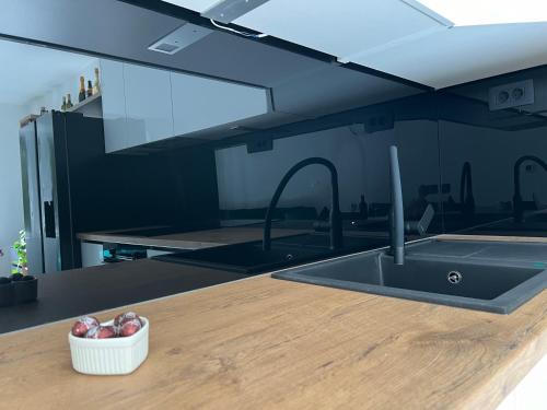 a kitchen counter with a sink and a bowl of onions at Sun Fun APT in Omiš