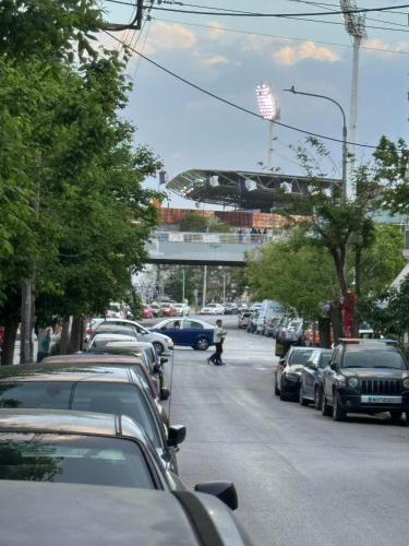 eine Straße mit geparkten Autos und einem Zug auf einer Brücke in der Unterkunft Thess Comfort House B in Thessaloniki