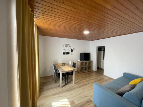 ein Wohnzimmer mit einem Tisch und einem blauen Sofa in der Unterkunft Kmetija Tomažič vinska klet - winery in Vipava