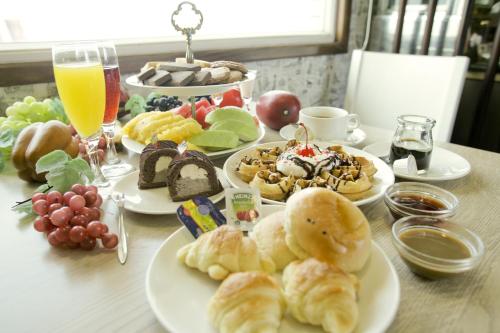 a table with plates of breakfast foods and drinks at Cambridge Tainan Hotel in Tainan