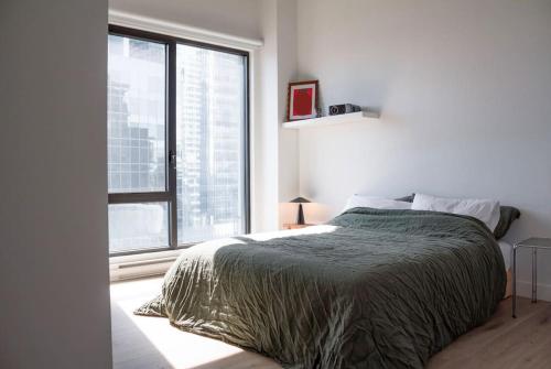 a bedroom with a bed and a large window at Stuning penthouse old montreal in Montreal