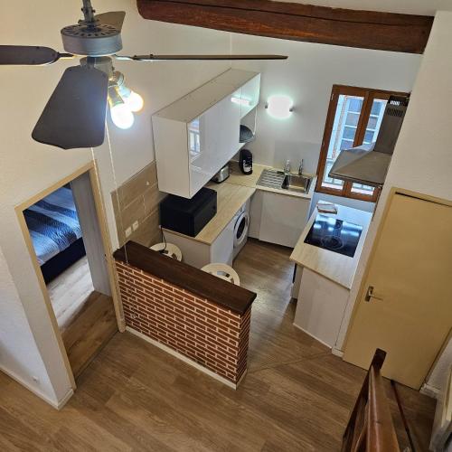 - une vue sur la cuisine avec des placards blancs dans l'établissement Charmes & Confort hypercentre Verdun entre Montauban et Toulouse, à Verdun-sur-Garonne