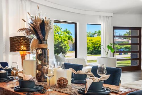 a dining room with a table with plates and candles at Casa Olan - Luxury Family Oasis 3BR North Miami Beach Villa with Saltwater Pool & Canal Views in Miami