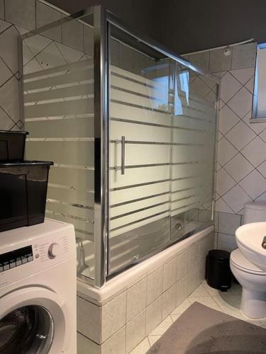 a bathroom with a shower and a washing machine at Areti's Home in Igoumenitsa