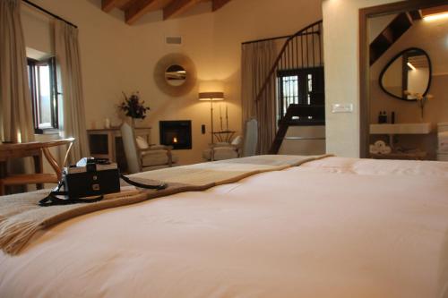 a bedroom with a large bed and a living room at HOTEL RURAL SANTUI in Horcajuelo de la Sierra