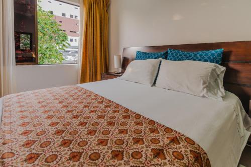 sypialnia z dużym łóżkiem z pomarańczowym i białym kocem w obiekcie Casa Hotel Miriam w mieście Montería