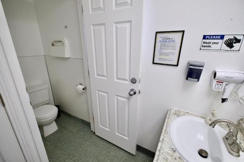 a bathroom with a toilet and a sink and a door at Yosemite Bug Rustic Mountain Resort in Midpines