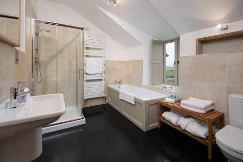 a bathroom with a tub and a shower and a sink at Heiton Mill House in Kelso